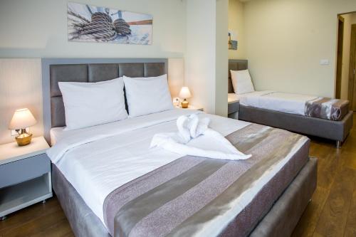 a hotel room with two beds with towels on it at Hotel Olimpija plus in Herceg-Novi