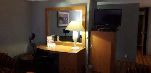 a room with a desk with a lamp and a television at Hotel Mexicali in Mexico City