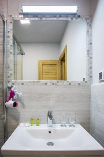 a bathroom with a sink and a large mirror at Hotel Olimpija plus in Herceg-Novi