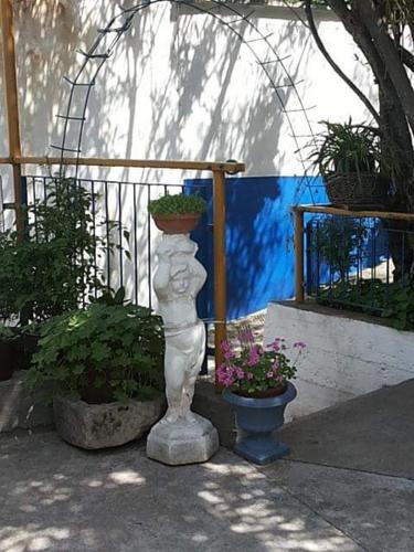 a statue with a planter on it next to some plants at Hostel -Sema in Mostar