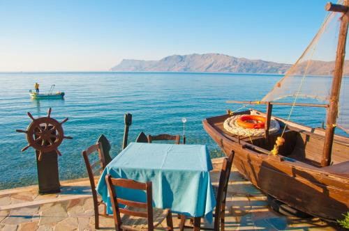 a table and a boat on the water at Akrogiali in Kissamos