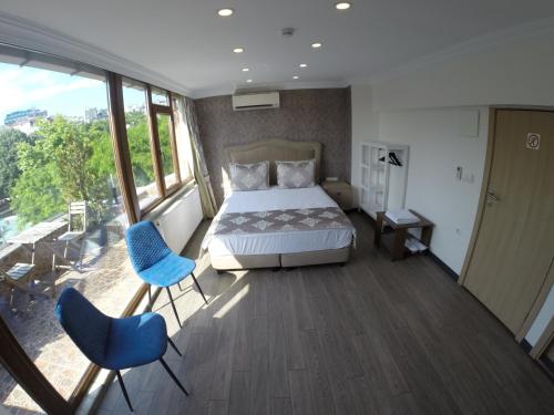 a bedroom with a bed and two blue chairs at Meydan Suites in Istanbul