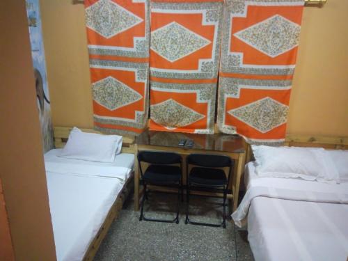 a room with two beds and a table and chairs at Feehi's Place in Accra