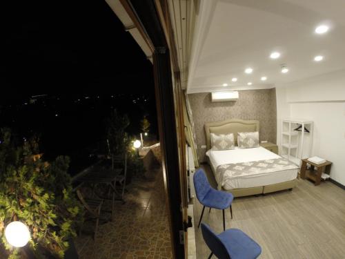a bedroom with a bed and two blue chairs at Meydan Suites in Istanbul