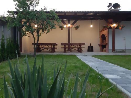 two benches sitting under a pavilion in a garden at Apartments Travel in Otočac