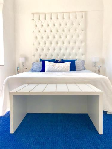 a large white bed with a large white padded headboard at Sky House Amalfi Coast in Scala