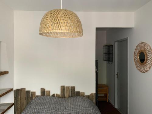 a bedroom with a bed and a pendant light at Appartement rénové & calme - Centre-ville 4 à 6 Pers - 2eme Étage Cuisine Équipée- Linge et Ménage en option in Cauterets