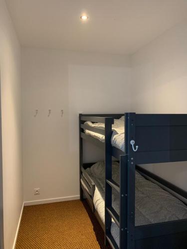 Cette chambre dispose de lits superposés et de murs blancs. dans l'établissement cauterets nid douillet rénové, à Cauterets