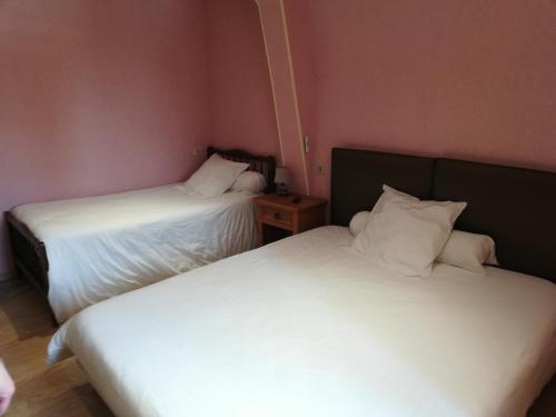 two beds in a small room with white sheets at Hôtel de la Poste Chez Cécile in La Grande-Verrière