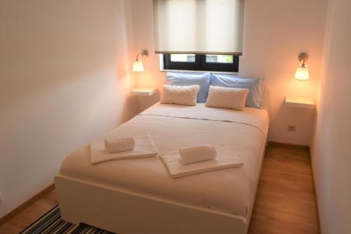 a bedroom with a white bed with two towels on it at Casa da Romeira in Ponte de Lima