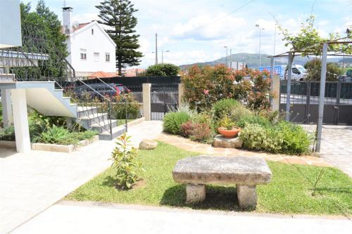 a stone bench sitting in the middle of a garden at Casa da Romeira in Ponte de Lima