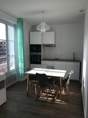 une cuisine avec une table et des chaises dans une pièce dans l'établissement Appartement 5MN plages CANNES la Bocca, à Cannes