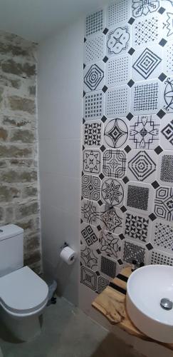 a bathroom with a toilet and a black and white wall at Saint Antonio Maroni in Maroni