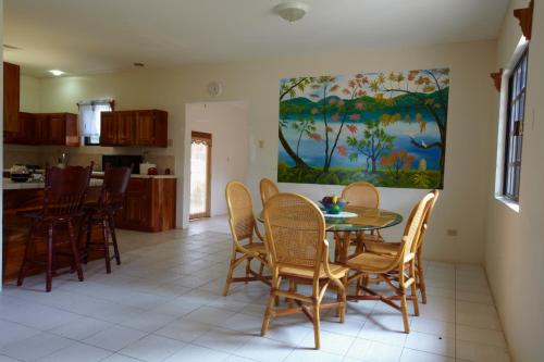 a kitchen with a table and chairs in it at Black Orchid Resort in Burrell Boom