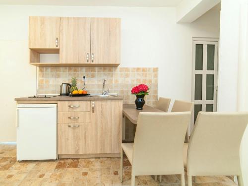 a kitchen with wooden cabinets and a table with chairs at Apartments Fillip in Petrovac na Moru
