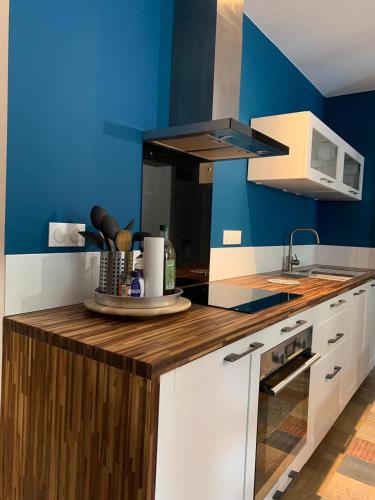 une cuisine avec des murs bleus et un comptoir en bois dans l'établissement cauterets nid douillet rénové, à Cauterets
