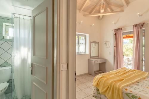 a bedroom with a bed and a bathroom at Electra Houses in Stoupa