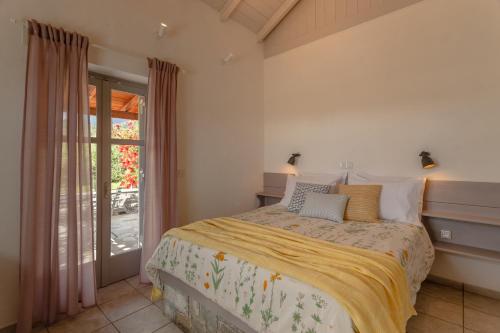 a bedroom with a bed and a sliding glass door at Electra Houses in Stoupa