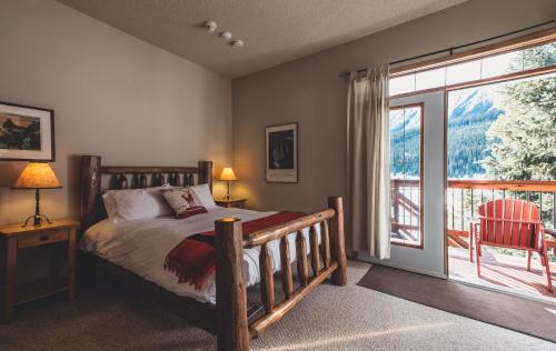 sypialnia z łóżkiem i dużym oknem w obiekcie Mount Engadine Lodge w mieście Kananaskis Village