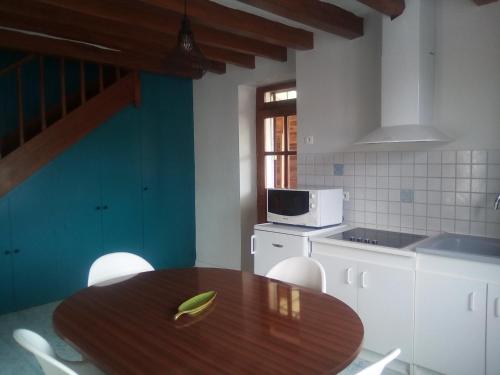 a kitchen with a wooden table and a microwave at Châteaux de la Loire Zoo de Beauval in Pontlevoy