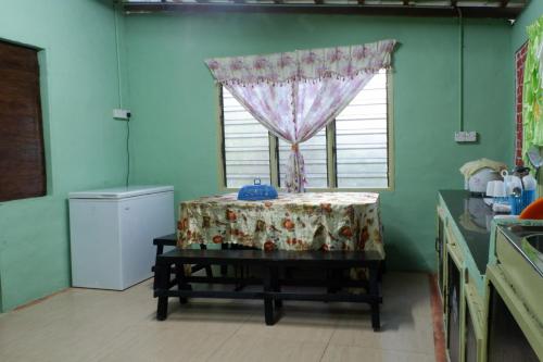 Homestay Tok Abah Kuala Rompin 1 Bilik Tidur في كوالا رومبين: مطبخ مع طاولة ونافذة