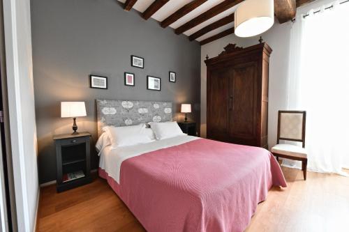 Maison Canterou في Monein: غرفة نوم بسرير كبير مع بطانية وردية