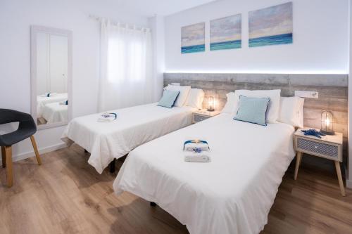 two beds in a room with white and blue at ✪dona Apartment in Las Palmas de Gran Canaria