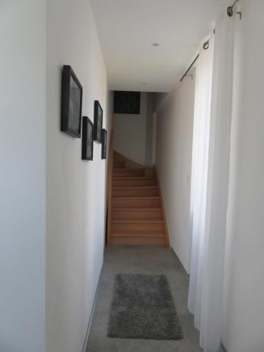 a hallway with white walls and a stair case at Les Rives des Habsbourg in Ensisheim