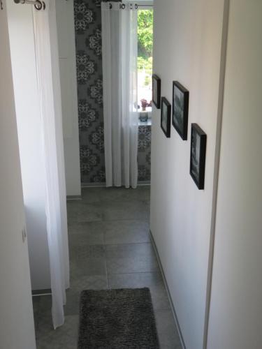 a hallway with pictures on the wall and a mirror at Les Rives des Habsbourg in Ensisheim