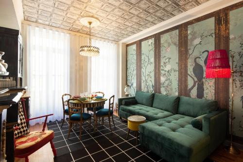 a living room with a green couch and a table at Casa do Papel - Charm in Matosinhos in Matosinhos