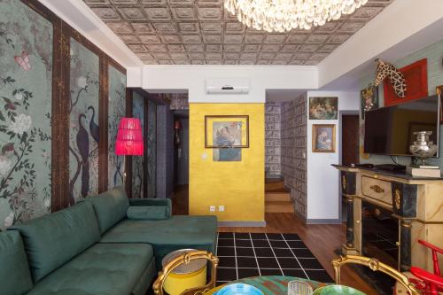 a living room with a green couch and a yellow wall at Casa do Papel - Charm in Matosinhos in Matosinhos