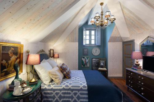 ein Schlafzimmer mit einem blauen und weißen Bett und einem Kronleuchter in der Unterkunft LovelyStay - Casa do Papel - Charm in Matosinhos in Matosinhos
