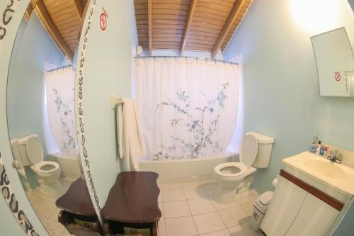 a bathroom with two toilets and a tub and a sink at Chin Cozy@ Rhyne Park in Montego Bay