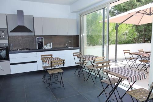 uma cozinha com mesas e cadeiras e um guarda-sol em Sunrise B&B Sicilia Avola em Avola