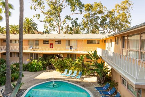 an exterior view of a resort with a pool and chairs at Cal Mar Hotel Suites in Los Angeles