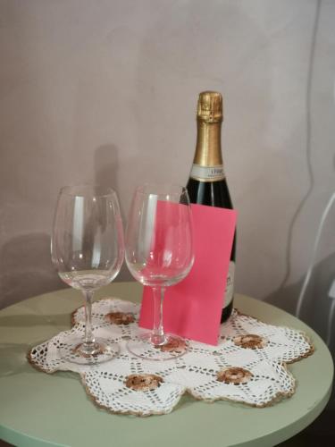 two wine glasses on a table with a bottle of wine at Maison Croix de Ville in Aosta