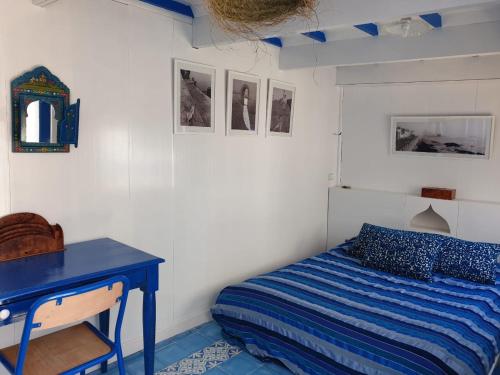 a bedroom with a bed and a blue desk at Riad Terre d'Azur in Essaouira