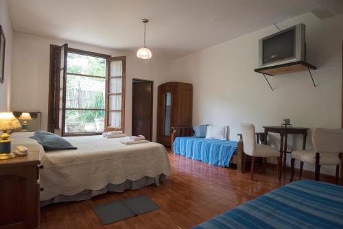 Habitación de hotel con 2 camas y TV en Hostal El Cerrito San Lorenzo en San Lorenzo