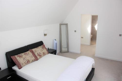 - une chambre avec un lit blanc et un miroir dans l'établissement Modern **Pet friendly** 3 bed beach view Town House near Dover ,Canterbury ,Folkestone and Hythe Kent, à Hythe