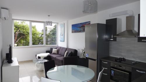 een keuken en een woonkamer met een bank en een tafel bij Apartment Spartium Split in Split