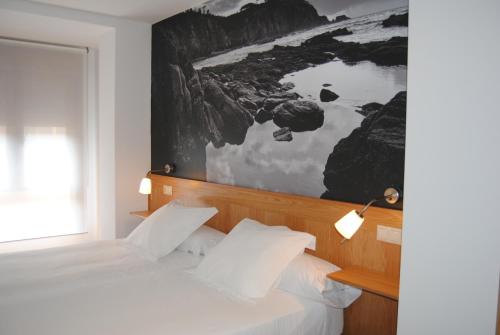 1 dormitorio con 2 camas y un cuadro en la pared en Hotel Dabeleira, en Luarca