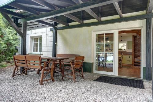 un patio con mesa de madera y sillas en Warmińska Winnica en Barczewo