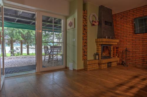 a living room with a fireplace and a sliding glass door at Warmińska Winnica in Barczewo