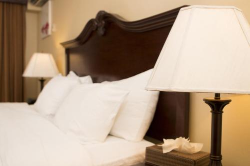 a bedroom with a bed with a lamp and pillows at Baldi Hot Springs Hotel & Spa in Fortuna