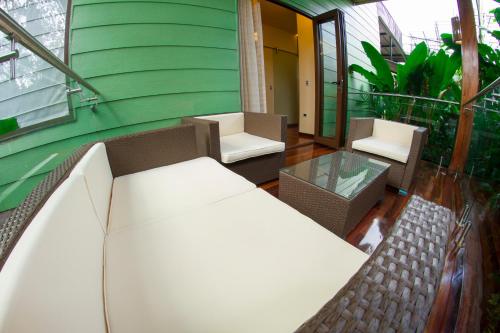 a balcony with two chairs and a glass table at Baldi Hot Springs Hotel & Spa in Fortuna