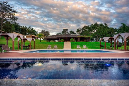 a swimming pool with chairs and a gazebo at Pousada Boyrá in Bonito