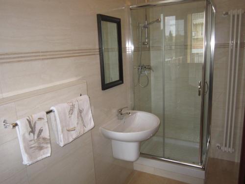 a bathroom with a sink and a shower with towels at B&B Casa Murgiana in Gravina in Puglia