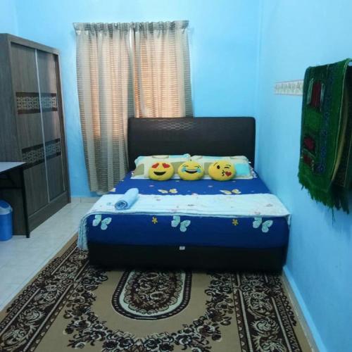 a blue bedroom with a bed with hello kitty pillows at Saujana Homestay in Ranau