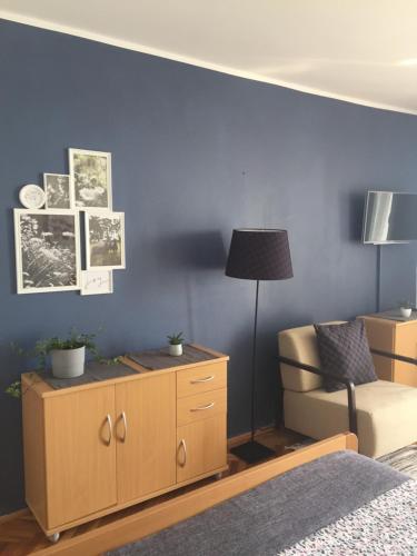a bedroom with a blue wall with a bed and a chair at Guesthouse Punta Mira - Beachfront in Novalja