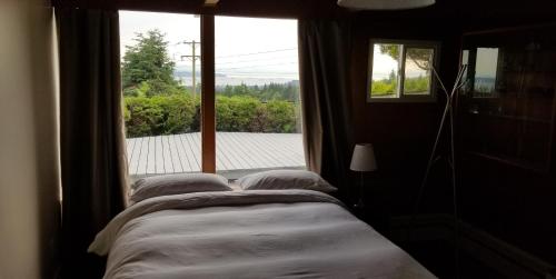 a bedroom with a bed and a large window at City Gardens Suites B&B in North Vancouver